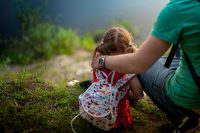 father and daughter sitting on the Bank of the river